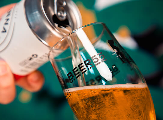 pouring a craft beer can into a Beer52 branded glass